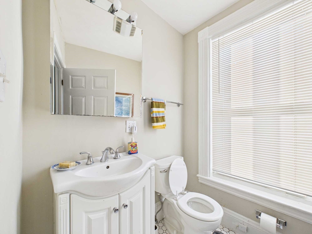 16-22 Reedsdale Street Boston, MA 02134 - Photo 28 of 39 a bathroom with a sink a toilet and a mirror