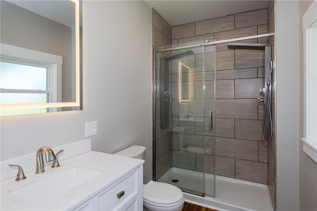 1217 Jasper Road Xenia, OH 45385 - Photo 38 of 62 This modern bathroom features a stylish vanity, sleek fixtures, and a spacious glass-enclosed double shower.