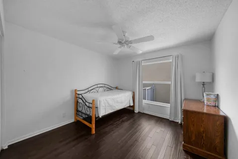 a view of an empty room with wooden floor and window