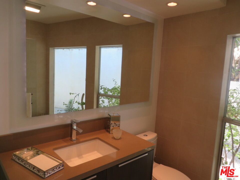 9659 Cedarbrook Drive Beverly Hills, CA 90210 - Photo 13 of 21 a bathroom with a sink a toilet and a mirror