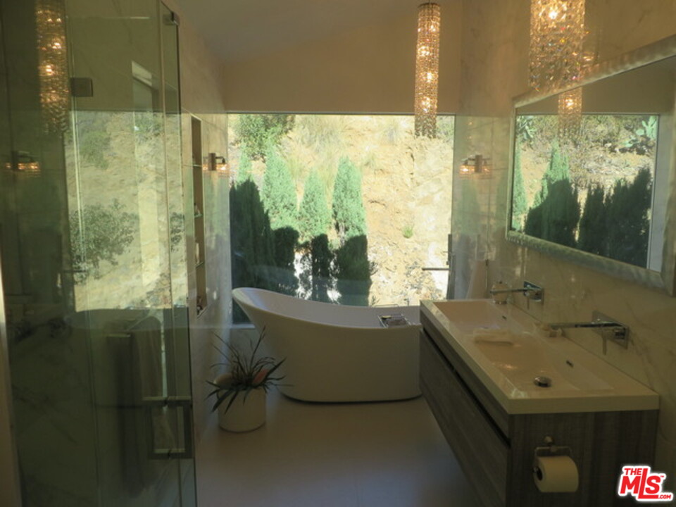 9659 Cedarbrook Drive Beverly Hills, CA 90210 - Photo 18 of 21 a bathroom with a sink and mirror with bathtub