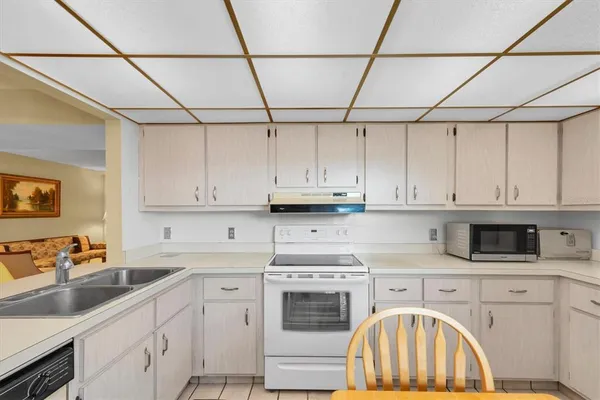 a kitchen with stainless steel appliances granite countertop a refrigerator a stove a sink dishwasher and white cabinets with wooden floor