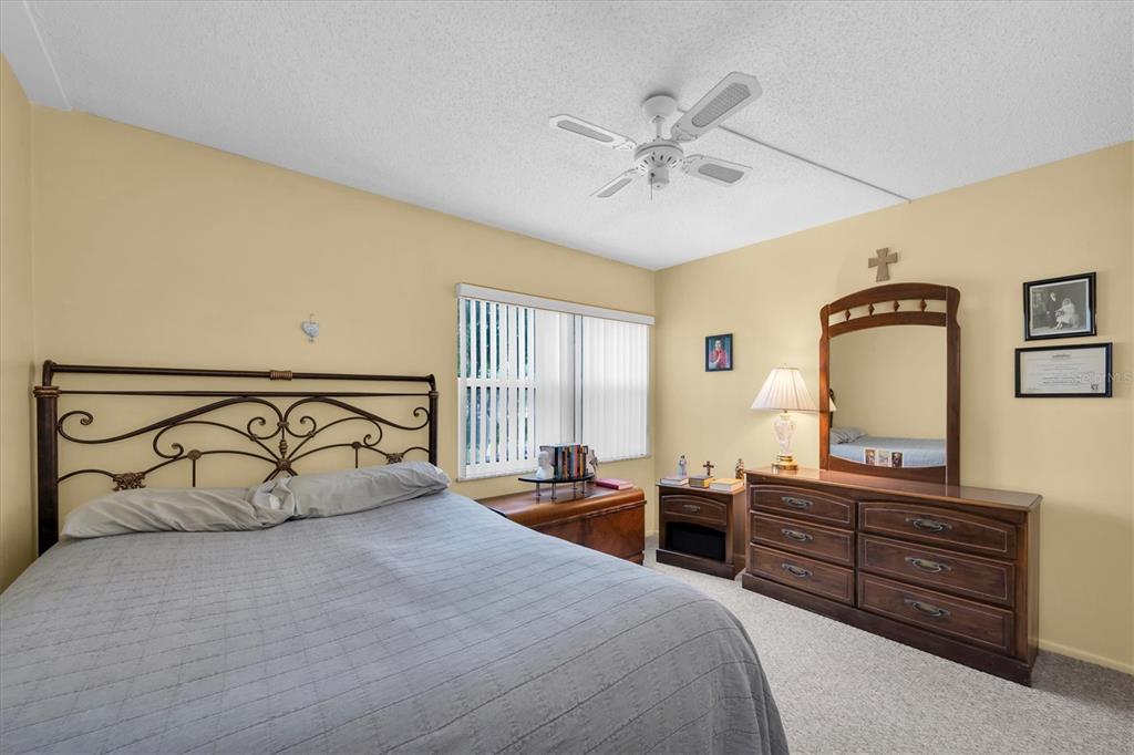 12300 Vonn Road, Unit 4101 Largo, FL 33774 - Photo 27 of 46 a bedroom with a bed and dresser with mirror