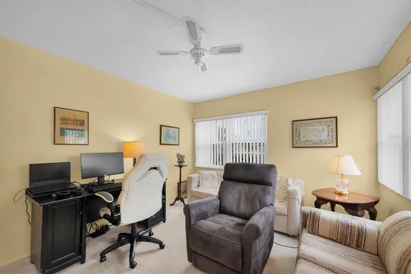a living room with furniture a ceiling fan and a window