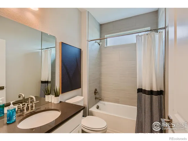 a bathroom with a granite countertop sink mirror toilet and bathtub