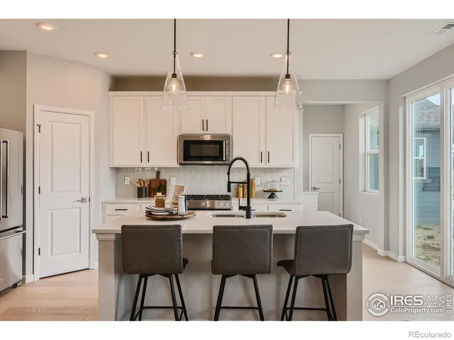 a kitchen with kitchen island granite countertop a sink cabinets and stainless steel appliances