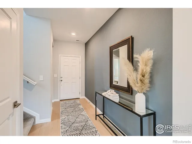 a view of entryway and hall with wooden floor
