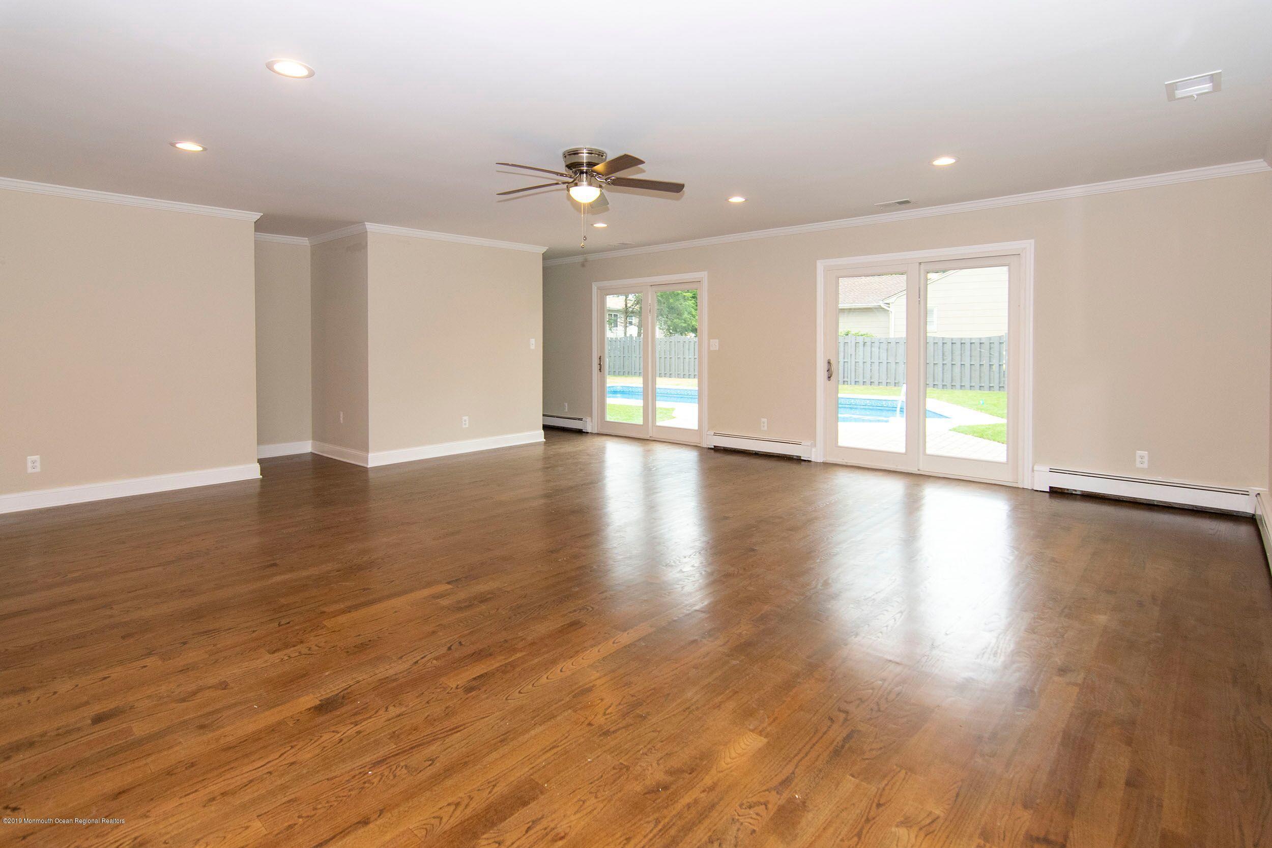 654 Thoroughfare Road Brick, NJ 08724 - Photo 3 of 17 a view of an empty room with wooden floor and a window