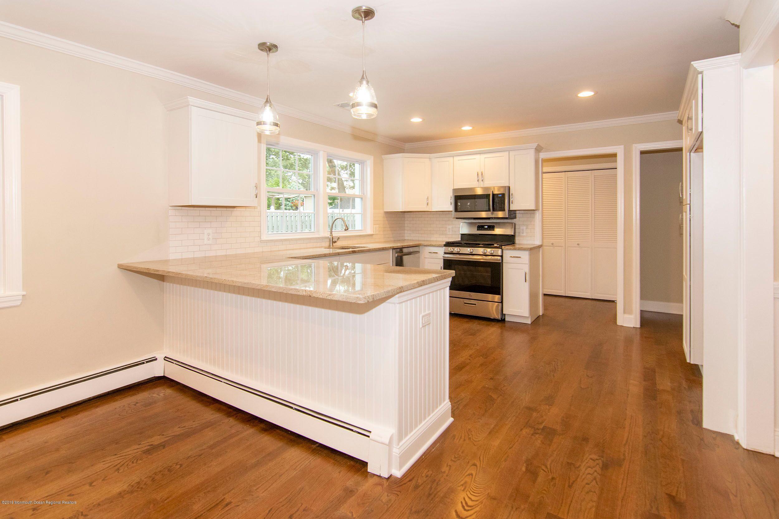 654 Thoroughfare Road Brick, NJ 08724 - Photo 4 of 17 a kitchen with stainless steel appliances granite countertop a stove and a refrigerator
