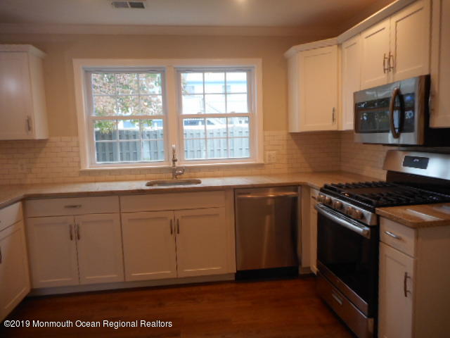654 Thoroughfare Road Brick, NJ 08724 - Photo 6 of 17 a kitchen with stainless steel appliances granite countertop a stove a sink and a microwave
