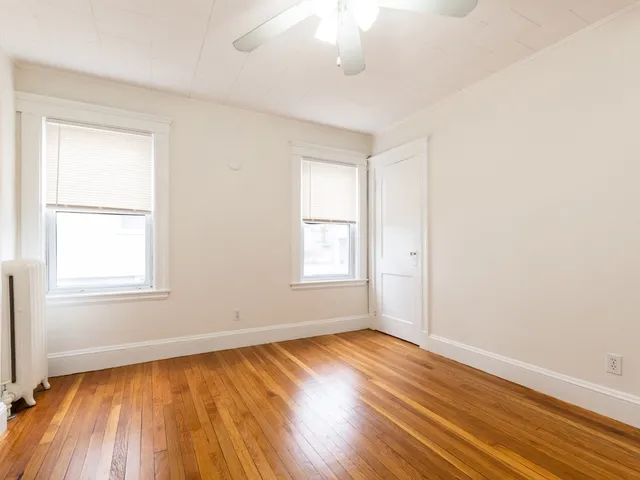 an empty room with wooden floor and closet