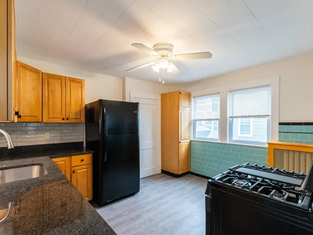a view of an empty room with window closet and wooden floor