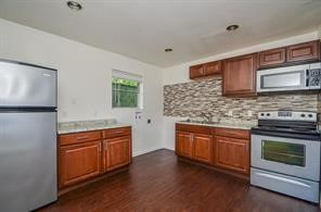7525 Bauman Road Houston, TX 77022 - Photo 4 of 9 a kitchen with stainless steel appliances granite countertop a stove a sink and a microwave