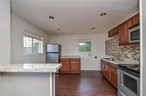 7525 Bauman Road Houston, TX 77022 - Photo 5 of 9 a kitchen with stainless steel appliances granite countertop a stove a sink and a refrigerator