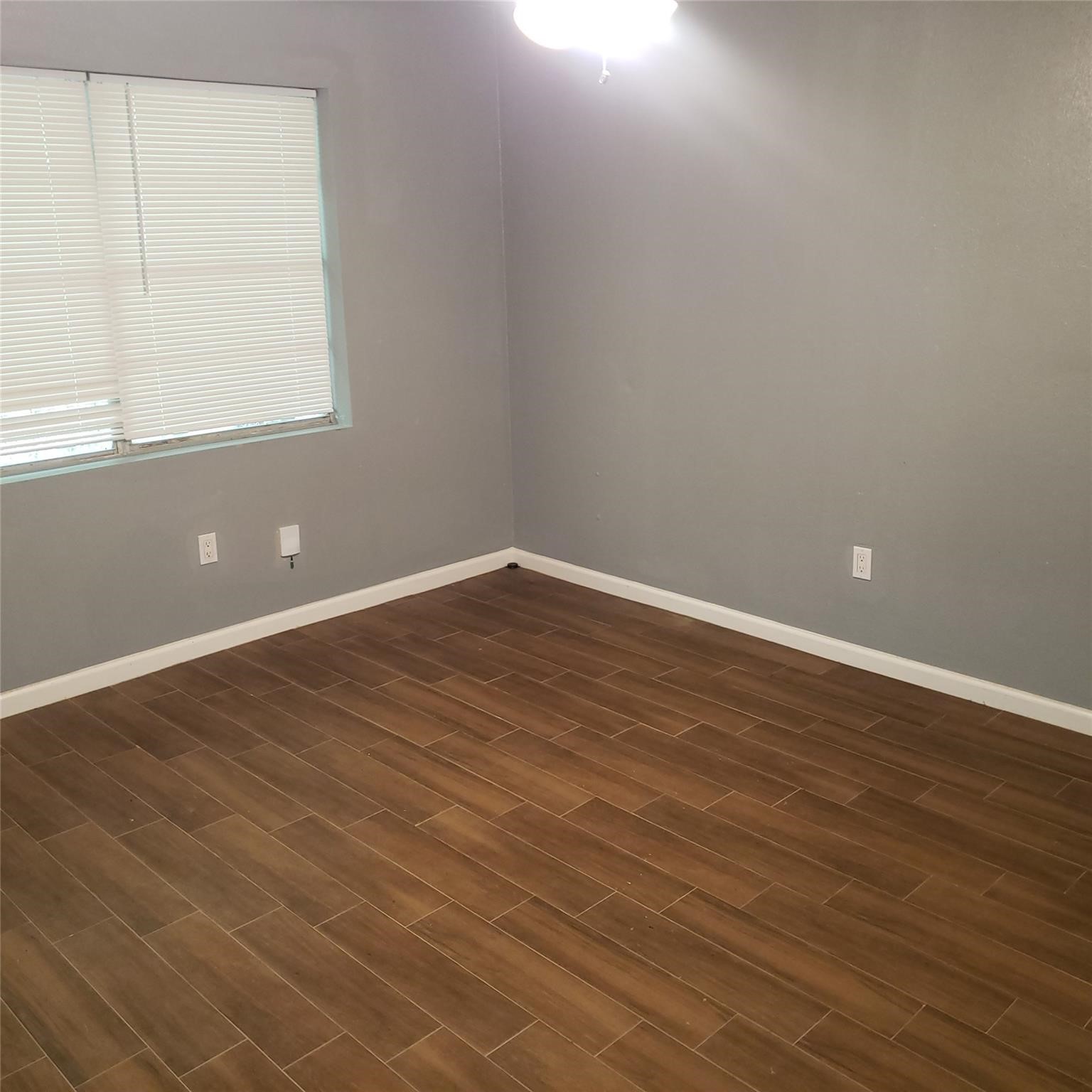 7525 Bauman Road Houston, TX 77022 - Photo 8 of 9 an empty room with wooden floor and windows