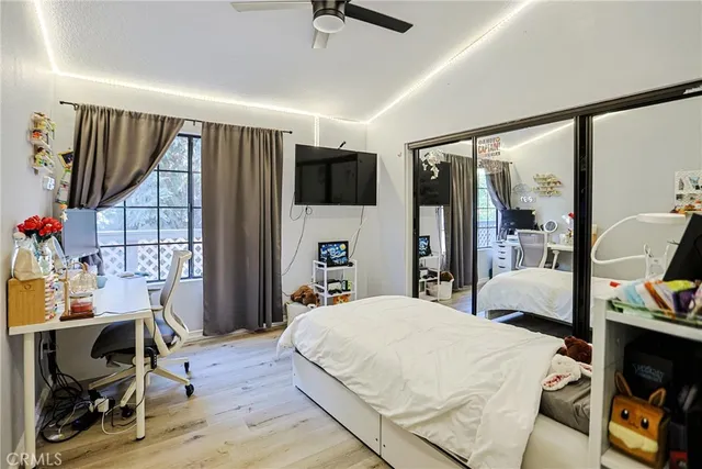 a bedroom with a bed a flat screen tv and a large window