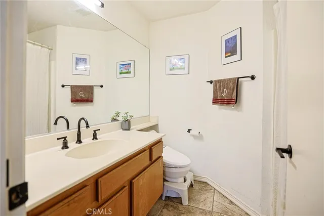 a bathroom with a sink mirror vanity and toilet