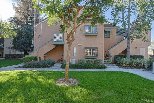 a front view of a house with garden and trees