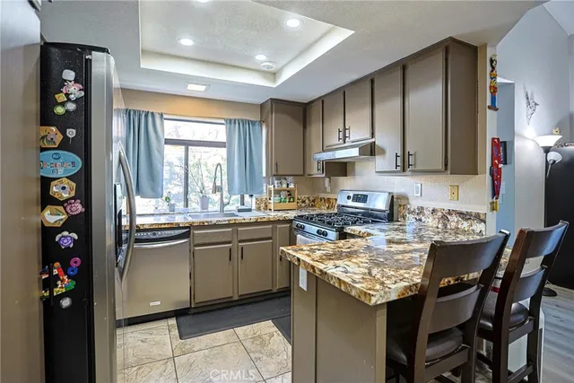 a kitchen with stainless steel appliances granite countertop a sink dishwasher and cabinets with wooden floor