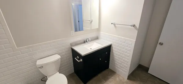 a bathroom with a toilet sink and mirror