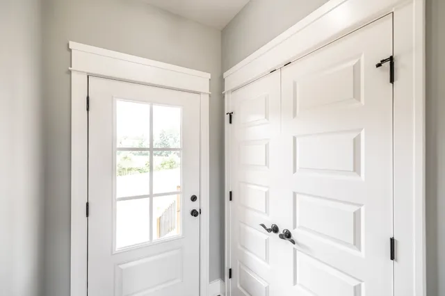 a view of an empty room with wooden floor and windows