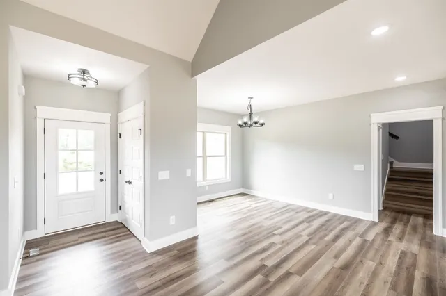 an empty room with windows and chandelier