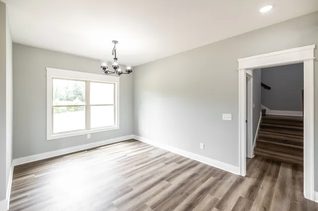 a kitchen with stainless steel appliances granite countertop a sink a stove a refrigerator and island with wooden floor