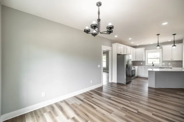 a view of a kitchen with a sink wooden floor and a cabinet