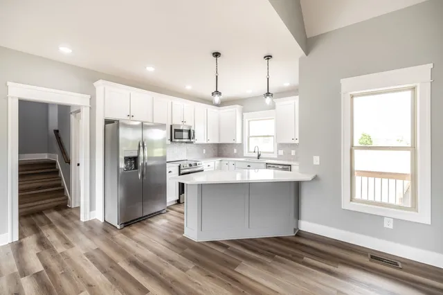 a kitchen with white cabinets sink and stainless steel appliances
