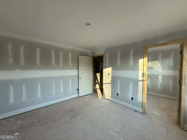 a view of a livingroom with a fireplace a ceiling fan and windows
