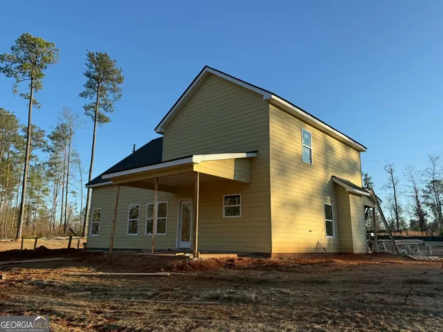 a backyard of a house with table and chairs