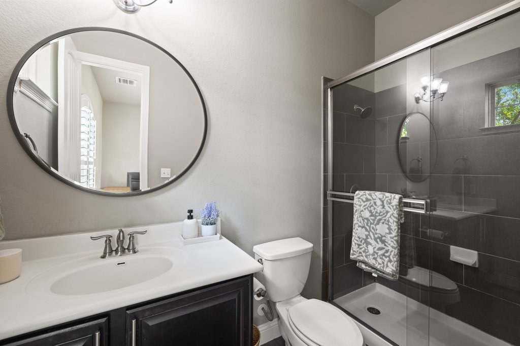 305 Enchanted Hilltop Way Austin, TX 78738 - Photo 21 of 28 Full bathroom with vanity, a shower stall, a chandelier, and a textured wall