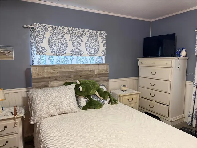 a bedroom with a bed and a tv