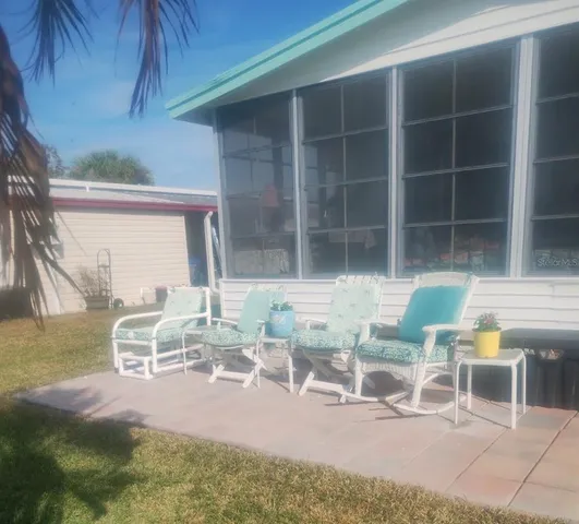a view of a patio with table and chairs and potted plants