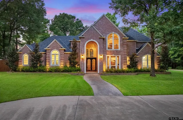 a front view of a house with a garden and trees