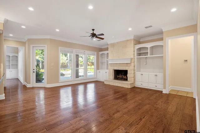 an empty room with wooden floor and a fireplace