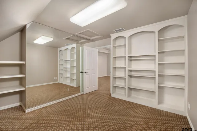 a view of walk in closet with empty racks