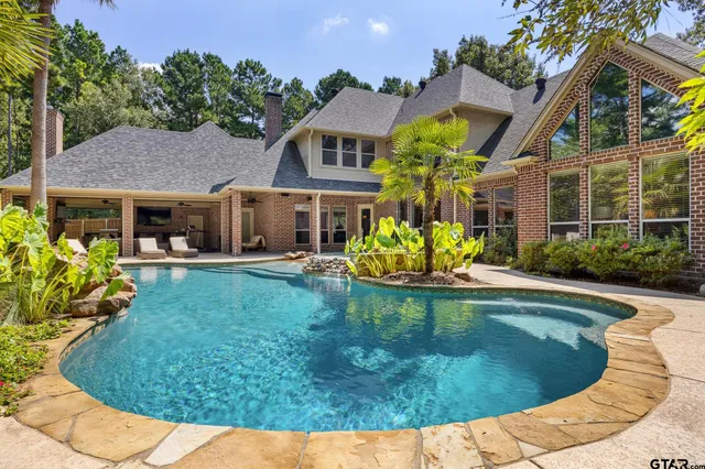 a view of a house with swimming pool and sitting area