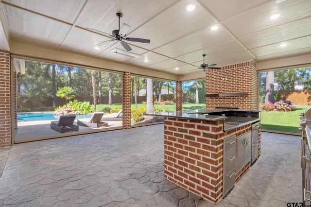 a kitchen with stainless steel appliances granite countertop a stove and a view of living room