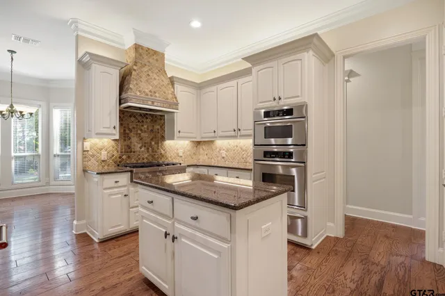 a kitchen with stainless steel appliances granite countertop a stove and a refrigerator