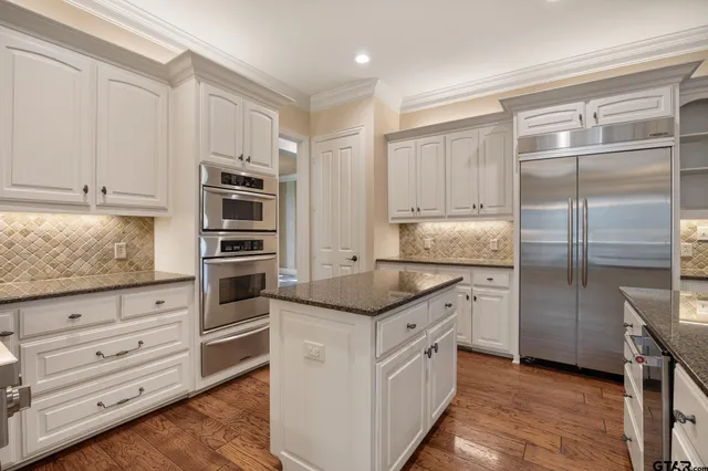 a kitchen with stainless steel appliances granite countertop a stove and a refrigerator