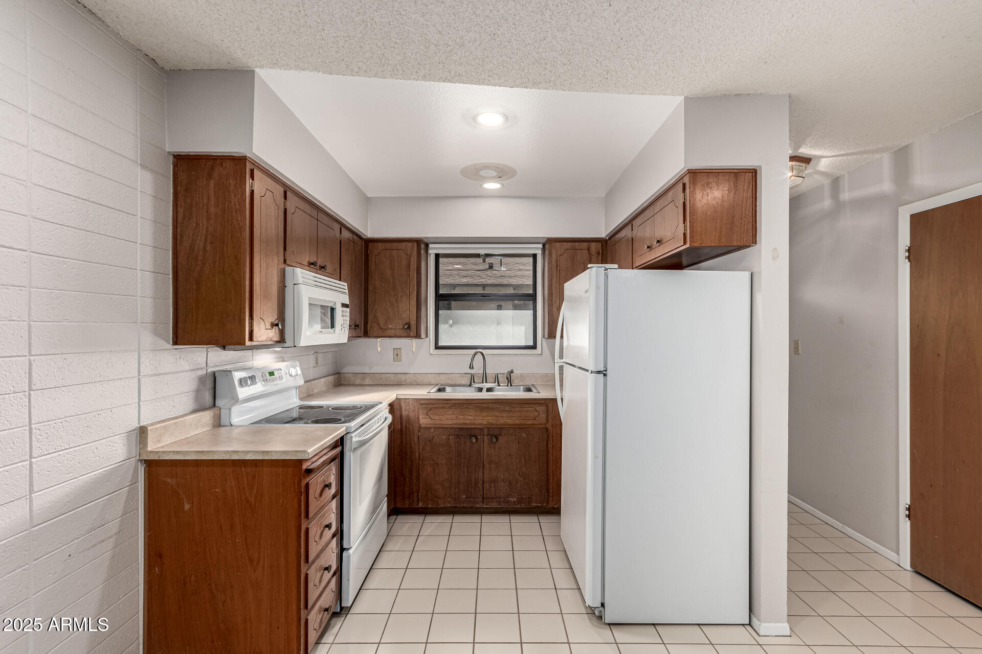 6721 East McDowell Road, Unit B314 Scottsdale, AZ 85257 - Photo 10 of 31 a kitchen with refrigerator and cabinets