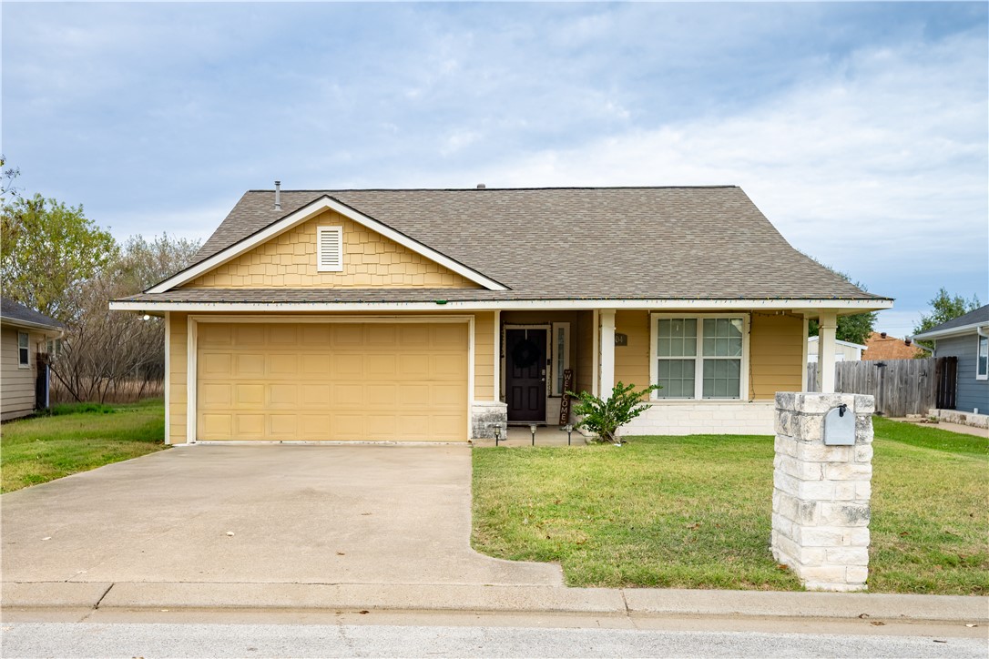 View of front facade featuring a shingled roof, driveway, a porch, and a garage