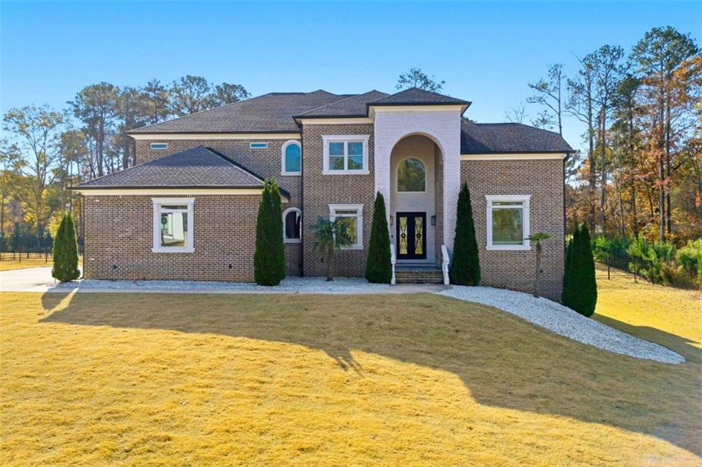 1616 Palmilla Way Southwest Stockbridge, GA 30281 - Photo 1 of 50 a view of a brick house with a yard