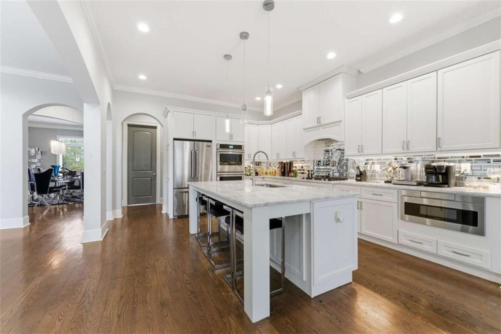 1616 Palmilla Way Southwest Stockbridge, GA 30281 - Photo 15 of 50 a kitchen with stove a refrigerator and a sink with wooden floor