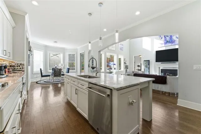a kitchen with granite countertop stainless steel appliances a stove a sink and cabinets