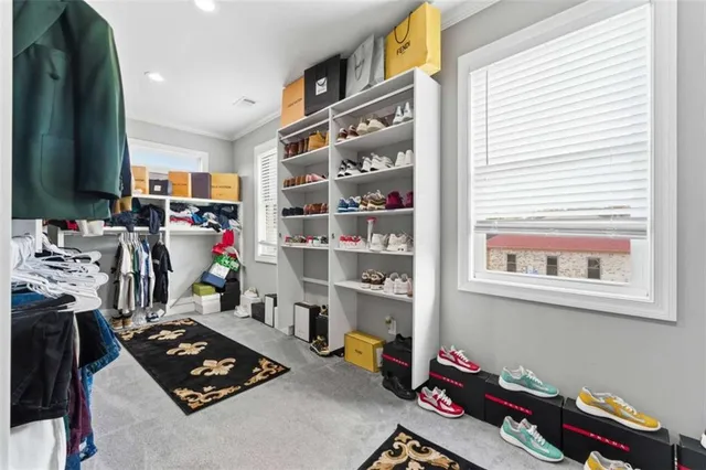 a view of walk in closet with clothes and shoes