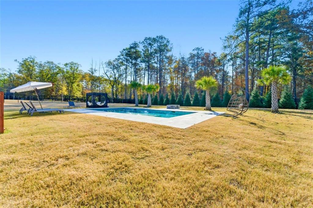 1616 Palmilla Way Southwest Stockbridge, GA 30281 - Photo 48 of 50 a swimming pool with outdoor seating and yard