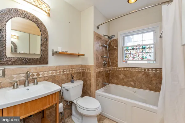 a bathroom with a sink a mirror a toilet and bathtub