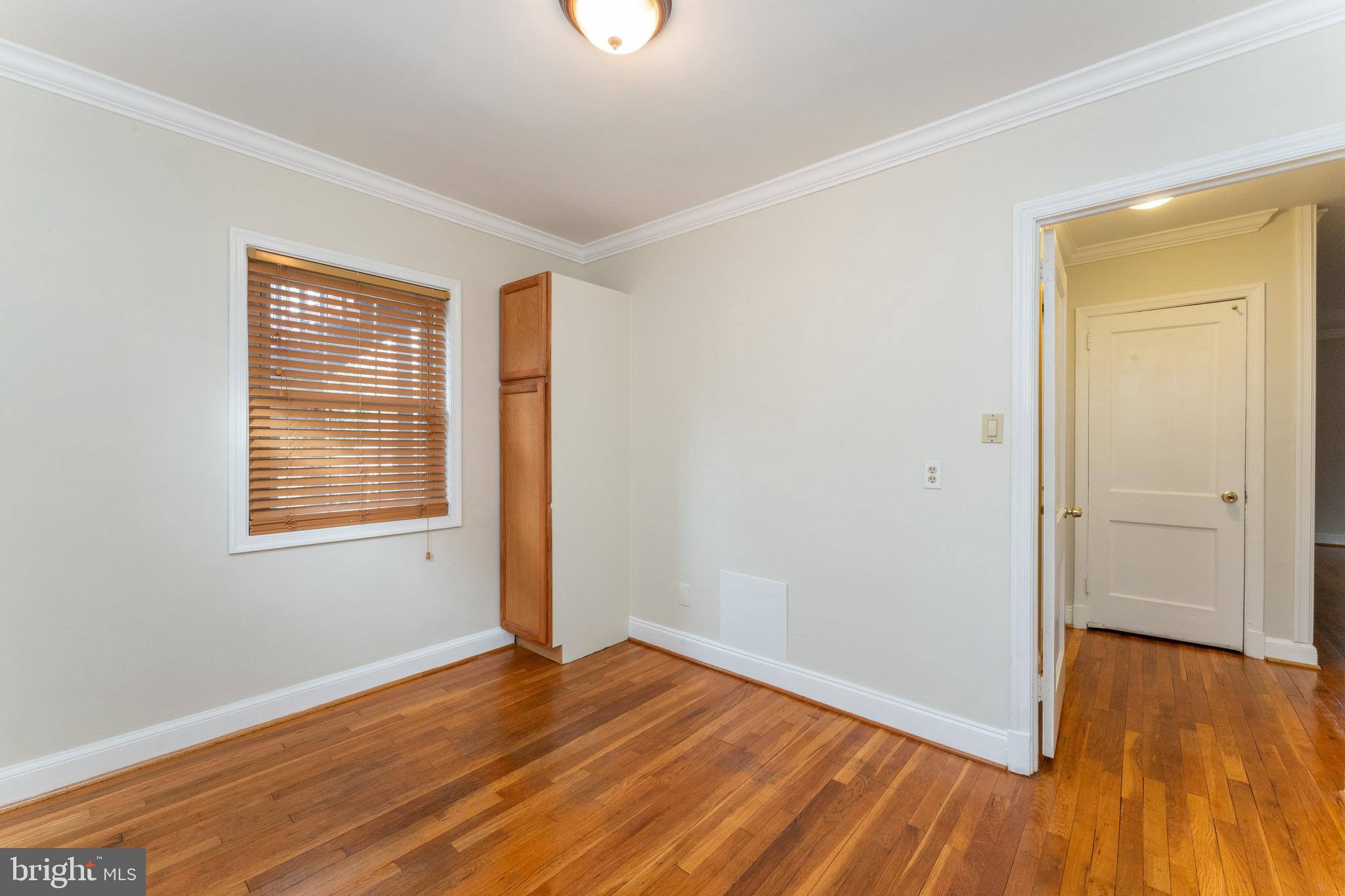 1609 Brisbane Street Silver Spring, MD 20902 - Photo 12 of 25 a view of an empty room with wooden floor and a window
